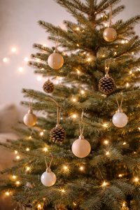 Vue rapprochée d'un sapin de Noël minimaliste orné de boules en bois et de pommes de pin, avec guirlande lumineuse douce