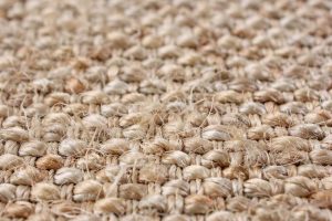 Gros plan sur les fibres naturelles et le tissage d'un tapis en sisal. Une texture brute et authentique parfaite pour une décoration écoresponsable