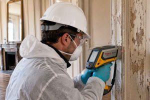 Un professionnel effectuant un diagnostic plomb dans un logement ancien avec un appareil à fluorescence X pour mesurer la concentration de plomb